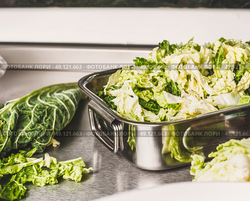 Cut Savoy cabbage in metal bowl on kitchen table. Стоковое фото, агентство Ingram Publishing / Фотобанк Лори