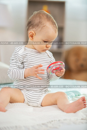 cute 6 month old baby playing with a teething toy. Стоковое фото, агентство Ingram Publishing / Фотобанк Лори
