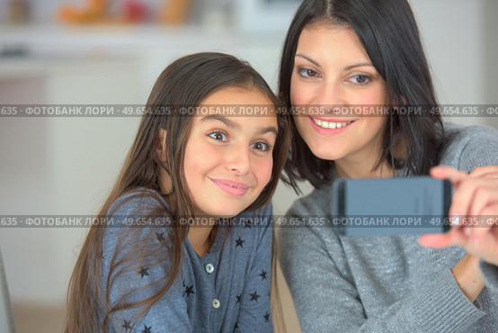 cute child and mother make selfie on mobile phone. Стоковое фото, агентство Ingram Publishing / Фотобанк Лори