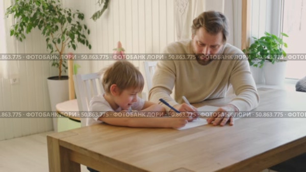 Dad teaches his son writing and counting. Kids primary education. Children learn, study in home school. Daddy male helping teaching little child boy support studying, learning homework. Knowledge day. Стоковое видео, видеограф Марина Демидюк / Фотобанк Лори