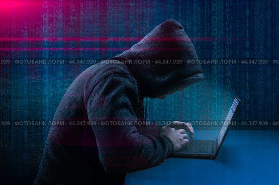 Dangerous Hooded Hacker Breaks into Government Data Servers. Cybersecurity, computer hacker with hoodie. Hideout Place has Dark Atmosphere. Hacking and malware concept. Стоковое фото, фотограф Павел Муравьев / Фотобанк Лори