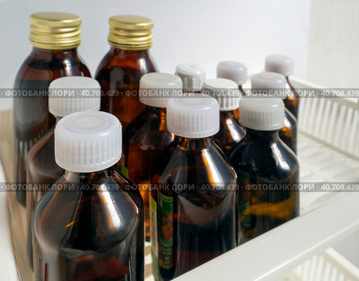 Dark medical glass vials of liquid medicines are neatly arranged on a shelf. Close-up. Medical background with tinctures, drops and other solutions. Стоковое фото, фотограф Бузмакова Светлана / Фотобанк Лори