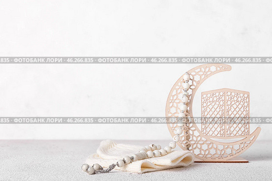 Decorative crescent, hat and Muslim prayer beads on light background. Стоковое фото, фотограф Pixel_shot / Фотобанк Лори
