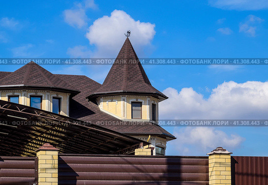 Decorative metal on the roof of a brick house. Fence made of corrugated metal. Стоковое фото, фотограф Леонид Еремейчук / Фотобанк Лори