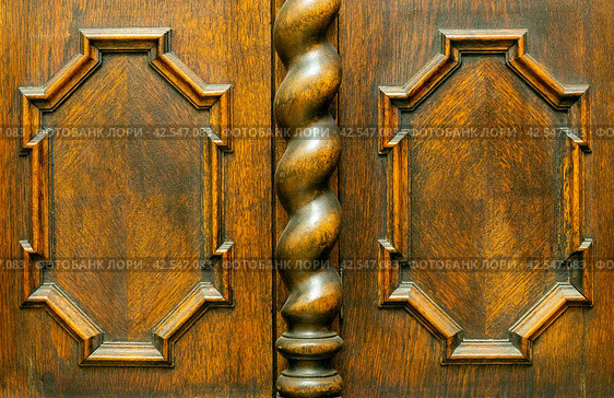 Decorative wooden elements of old vintage brown furniture. A curly baguette on an oak cupboard door and a carved twisted column. Vintage frames on wooden panels. Interior ancient decor. Стоковое фото, фотограф Константин Григорьев / Фотобанк Лори