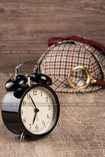 Deerstalker or Sherlock Hat and magnifying glass on Old Wooden table. Стоковое фото, агентство Ingram Publishing / Фотобанк Лори