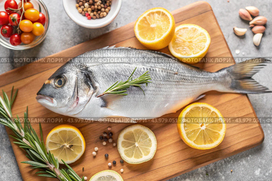 Delicious and healthy fish. Raw dorado with lemon and ingredients on a dark background. Banner, menu, place for recipe text, top view. Стоковое AI-изображение, AI-художник Photojuli / Фотобанк Лори