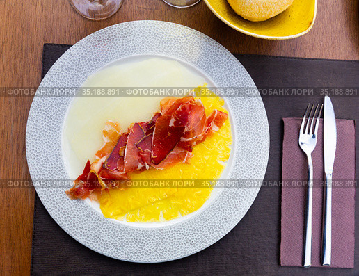 Delicious serving of pineapple and melon carpaccio with thinly sliced prosciutto. Стоковое фото, фотограф Яков Филимонов / Фотобанк Лори