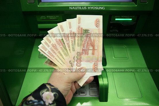 Деньги в  руке, банкноты по 5 тысяч рублей у банкомата СБЕР. Москва. 29.03.202. Стоковое фото, фотограф Ольга Зиновская / Фотобанк Лори