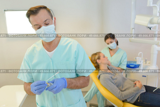 dentist curing a woman patient in the dental office. Стоковое фото, агентство Ingram Publishing / Фотобанк Лори