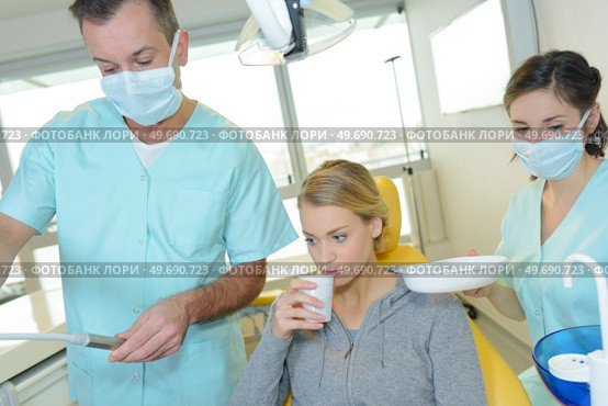 dentist curing a woman patient in the dental office. Стоковое фото, агентство Ingram Publishing / Фотобанк Лори