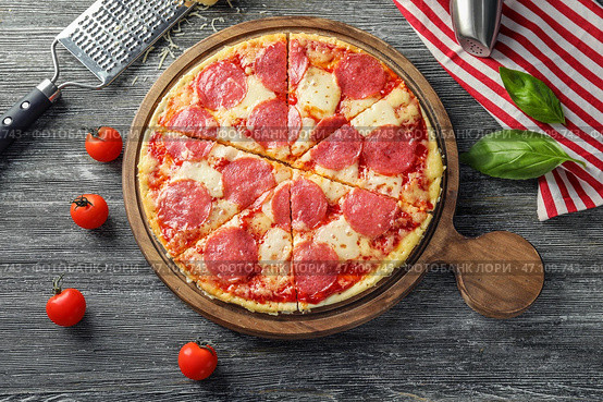 Деревянная доска с вкусной пиццей пепперони на столе. Стоковое фото, фотограф Pixel_shot / Фотобанк Лори