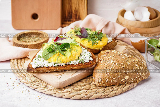Деревянная доска с вкусным бутербродом с яичницей на светлом фоне. Стоковое фото, фотограф Pixel_shot / Фотобанк Лори