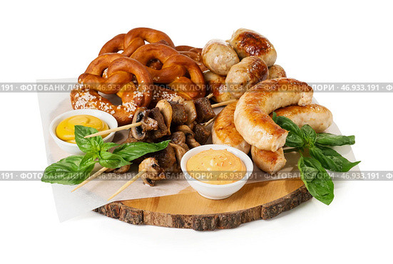 Деревянная доска с вкусными баварскими сосисками и закусками на белом фоне. Празднование Октоберфеста. Стоковое фото, фотограф Pixel_shot / Фотобанк Лори