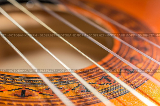 Detail of classic acoustic guitar with shallow depth of field.. Detail of classic acoustic guitar with shallow DOF and blur. Стоковое фото, агентство Ingram Publishing / Фотобанк Лори