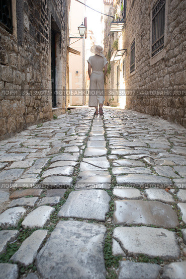 Detail shot of female legs wearing comfortable travel sandals walking on old medieval cobblestones street dring sightseeing city tour. Travel, tourism and adventure concept. Стоковое фото, фотограф Matej Kastelic / Фотобанк Лори