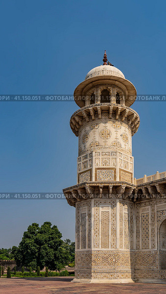 Details of the architecture of the ancient tomb of Itmad-Ud-Daulah. Marble minaret with balconies and a dome against the blue sky. On the walls there are ornaments, inlays of precious stones. India. (2022 год). Стоковое фото, фотограф Вера Ивановна Кубарева / Фотобанк Лори