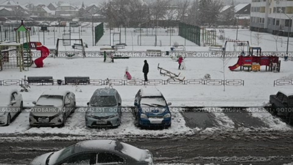 Детская площадка и автомобильная парковка зимой во время снегопада. Город Тюмень (2022 год). Редакционное видео, видеограф Александр Тараканов / Фотобанк Лори