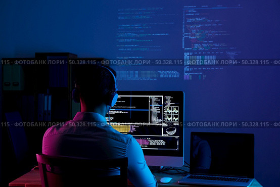 Developer working on code late at night, view from the back. Working all night long. Стоковое фото, агентство Ingram Publishing / Фотобанк Лори