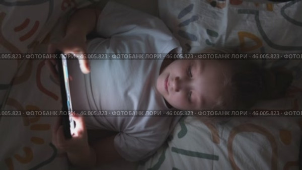 Девочка ночью играет в онлайн-игру на своем смартфоне. Зависимость детей от смартфонов. Зависимость от гаджетов. Стоковое видео, видеограф Терехова Марина / Фотобанк Лори