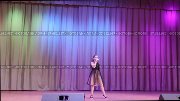 Девочка поет на сцене песню на праздничном мероприятии. A girl sings a song on stage at a festive event. Редакционное видео, видеограф Мария / Фотобанк Лори