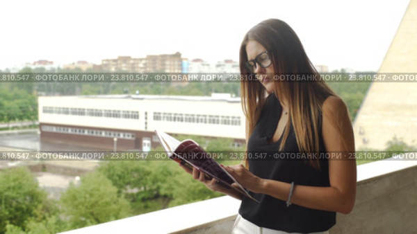 Девушка, читающая книгу на балконе. Стоковое видео, видеограф Виктор Аллин / Фотобанк Лори