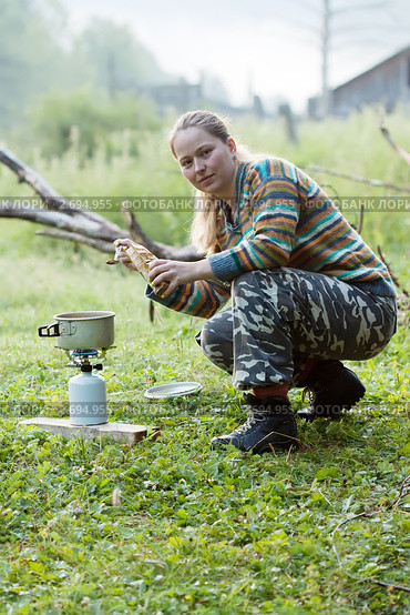 Девушка делает кофе на газовой горелке в лесу. Стоковое фото, фотограф Яков Филимонов / Фотобанк Лори