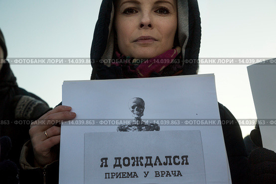 Девушка держит плакат с надписью "Я дождался приема у врача" на митинге в защиту здравоохранения "Право на жизнь!" на Суворовской площади города Москвы (2015 год). Редакционное фото, фотограф Николай Винокуров / Фотобанк Лори