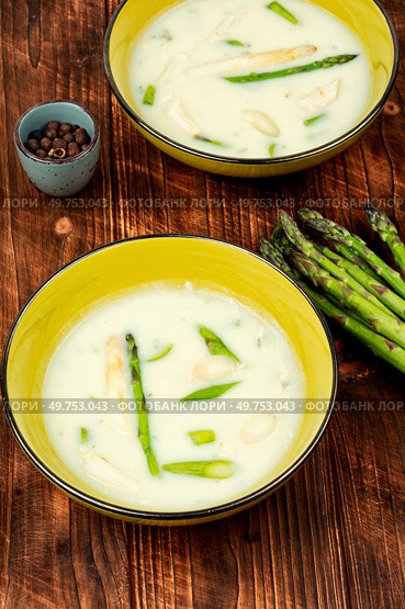Dietary vegetarian soup with white and green asparagus on rustic wooden table.. Asparagus soup on wooden background. Стоковое фото, агентство Ingram Publishing / Фотобанк Лори