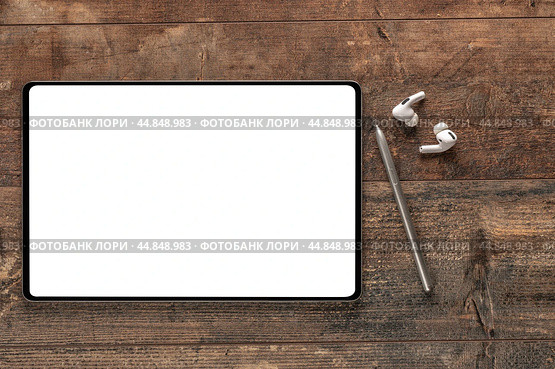 Digital tablet with empty white screen, stylus pen, wireless earphones on wooden rustic table. mockup. top view. Стоковое фото, фотограф Павел Муравьев / Фотобанк Лори