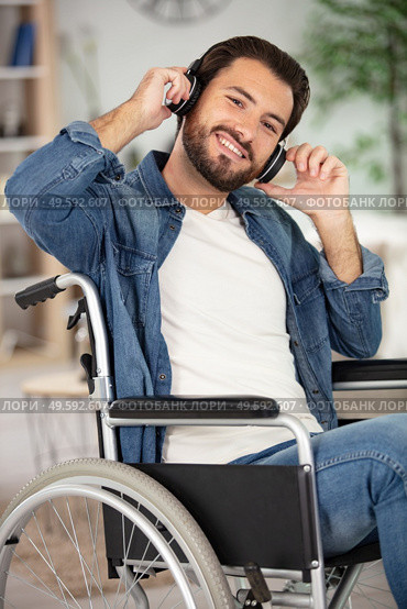 disabled man wearing headset and listening to music. Стоковое фото, агентство Ingram Publishing / Фотобанк Лори