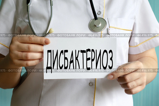 ДИСБАКТЕРИОЗ - слово на белом листе, который держит врач. Стоковое фото, фотограф Жанна Гапанович / Фотобанк Лори