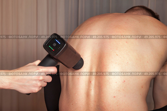 Discover the Benefits of Sports Massage With a Percussion Massager for Muscle Relief. Стоковое фото, фотограф Aleksandr Golubev / Фотобанк Лори