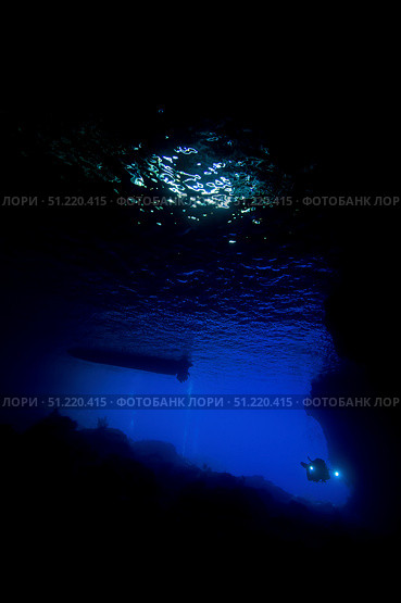 Diver with torchlight entering a cave in Christmas Island, Australia. Mathieu Meur/Stocktrek Images/TASS. Стоковое фото, агентство ТАСС / Фотобанк Лори