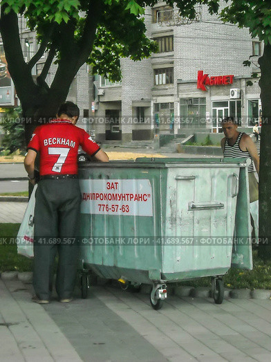 Dnipro, Ukraine - Circa June 2009. Two poors around a trash can close to Dnipro river embankment. Двое неимущих возле мусорного бака на набережной Днепра. Редакционное фото, фотограф Александр Кузнецов / Фотобанк Лори