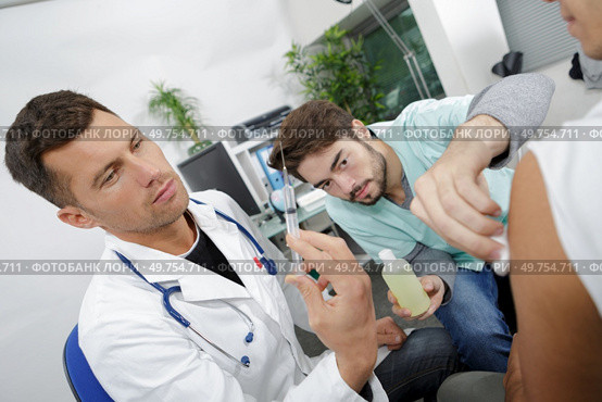 doctor and nurse doing injured man tetanus toxoid injection. Стоковое фото, агентство Ingram Publishing / Фотобанк Лори
