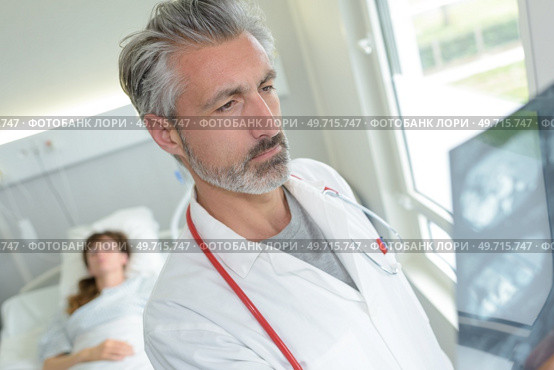doctor examining x-rays in patients room. Стоковое фото, агентство Ingram Publishing / Фотобанк Лори