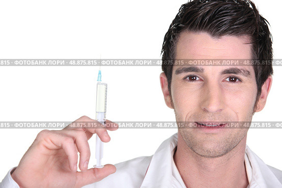 Doctor holding up an injection. Стоковое фото, агентство Ingram Publishing / Фотобанк Лори