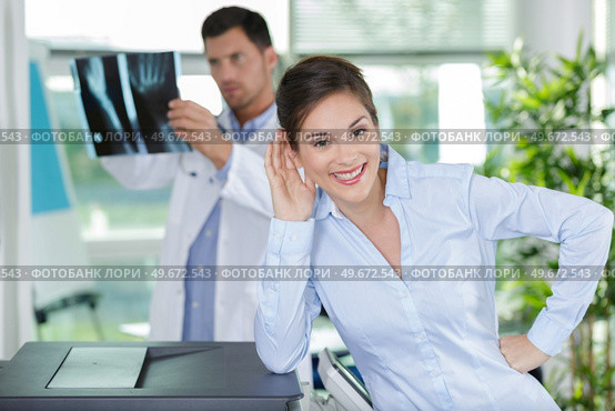 doctor holding x-ray imaging while patient is looking at camera. Стоковое фото, агентство Ingram Publishing / Фотобанк Лори