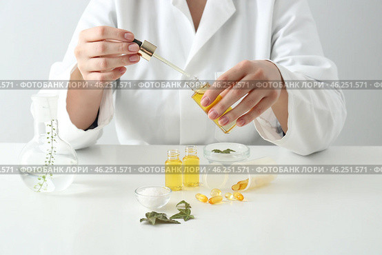 Doctor with natural essential oil at table. Стоковое фото, фотограф Pixel_shot / Фотобанк Лори