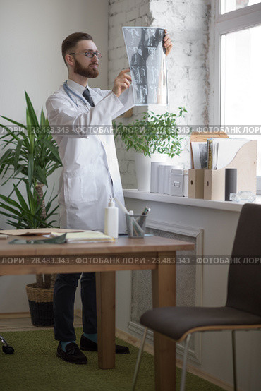 Doctor working with ct scan at hos workplace. Стоковое фото, агентство Ingram Publishing / Фотобанк Лори