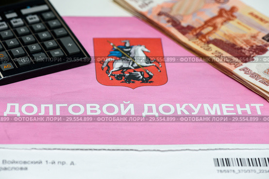 Долговой документ за коммунальные услуги, калькулятор и российские банкноты. Долг за квартиру (2018 год). Редакционное фото, фотограф Игорь Низов / Фотобанк Лори