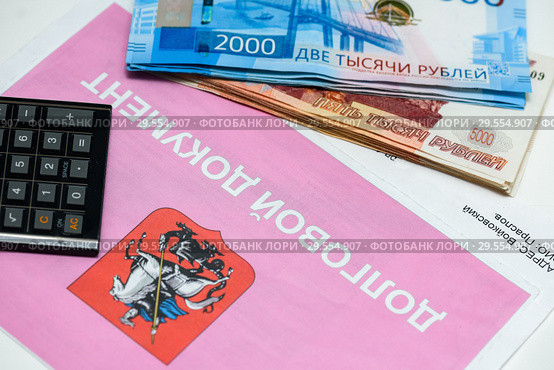 Долговой документ за коммунальные услуги, калькулятор и российские деньги. Долг за коммуналку (2018 год). Редакционное фото, фотограф Игорь Низов / Фотобанк Лори