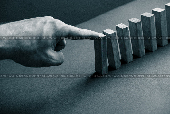Domino has Fallen in a Row. Domino theory. Effect. Hand with Finger is Pointing and Pushing the Falling Wood Blocks. Risk Management, Revolution Concept. Affect Business. Closeup. Manifestation. Red. Стоковое фото, фотограф Марина Демидюк / Фотобанк Лори