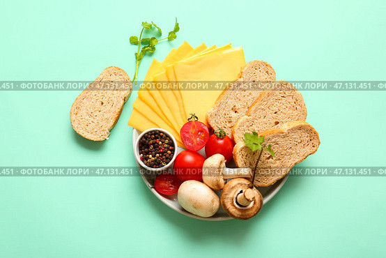Доска вкусного обработанного сыра с овощами и хлебом на бирюзовом фоне. Стоковое фото, фотограф Pixel_shot / Фотобанк Лори