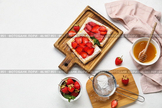 Доски с вкусным слоеным тестом, сахарной пудрой и миской с медом на столе. Стоковое фото, фотограф Pixel_shot / Фотобанк Лори