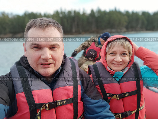 Довольные туристы в спасательных жилетах в лодке. Happy tourists in life jackets in a boat. (2022 год). Редакционное фото, фотограф Денис Баданин / Фотобанк Лори