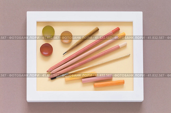 Drawing and creativity as a hobby. Pencils, watercolor paints, brush and pastel sticks in warm pink and peach tones in a white frame. Shades of trendy color Peach Fuzz. Flat lay, close-up, top view. Стоковое фото, фотограф Виктория Катьянова / Фотобанк Лори