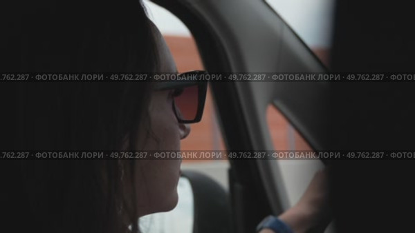 Driving Sunglasses Woman: Car interior view as she drives past building during daytime. Стоковое видео, видеограф svetograph / Фотобанк Лори