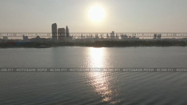 Drol flies over the bay of the sea at sunset, in the background of the skyscrapers of Dubai. Стоковое видео, видеограф Aleksey Kidisyuk / Фотобанк Лори